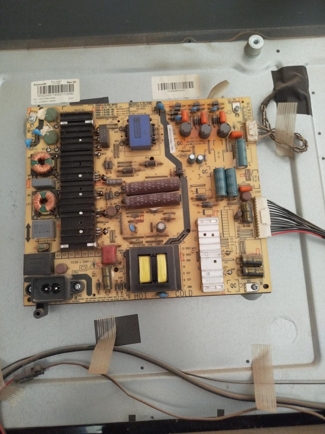 Placa de alimentación montada en un televisor abierto